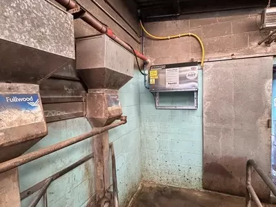 Dairy bay with the wall-mounted pressure washer installed at a raised height for safety at a farm in Atherstone